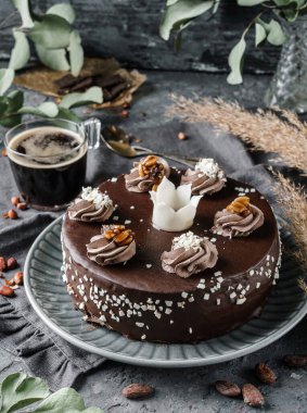 Koyu taşlı arka planda kremalı çikolatalı bisküvi, bitki ve fındıklı. Tatlılar, tatlı ve pasta, üst manzara, kapat.