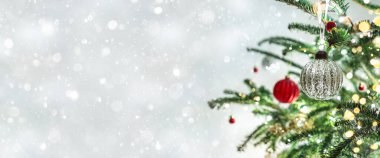 Kırmızı Noel süslemeleri olan bir Noel ağacı. Arka planda bokeh, bulanık, kıvılcımlı, parıltılı. Mutlu yıllar ve Xmas kartları, geniş pankart