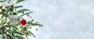 Kırmızı Noel süslemeleri olan bir Noel ağacı. Arka planda bokeh, bulanık, kıvılcımlı, parıltılı. Mutlu yıllar ve Xmas kartları, geniş pankart