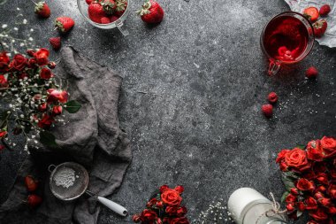 Yemek pişirmek ya da arka plan afişi yapmak. Peçeteli koyu gri beton arka plan, gül çiçekleri, böğürtlen, bir şişe süt. Üst görünüm, kopyalama alanı, metin alanı