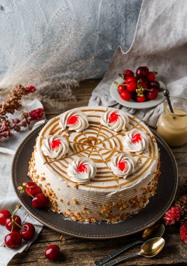 Kremalı lezzetli bisküvi keki ve ahşap kırsal arka planda bir fincan çay, çiçekler, böğürtlen. Tatlılar, tatlı ve pasta, ev yapımı kekler, kapatın.