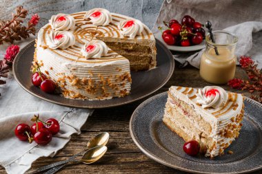 Kremalı lezzetli bisküvi keki ve ahşap kırsal arka planda bir fincan çay, çiçekler, böğürtlen. Tatlılar, tatlı ve pasta, ev yapımı kekler, kapatın.
