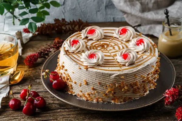 Kremalı lezzetli bisküvi keki ve ahşap kırsal arka planda bir fincan çay, çiçekler, böğürtlen. Tatlılar, tatlı ve pasta, ev yapımı kekler, kapatın.