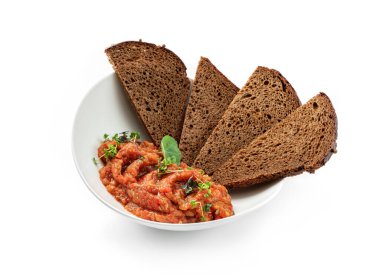 Sebzeli patlıcan salatası ve beyaz arka planda izole edilmiş tabakta bir dilim ekmek. Sağlıklı vejetaryen yemekleri, üst manzara, yakın çekim.