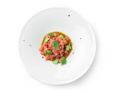 Ton balıklı tart, avokado ve sosla süslenmiş kişniş tabakta beyaz arka planda. Balık ve deniz ürünleri, yakın çekim, üst manzara.