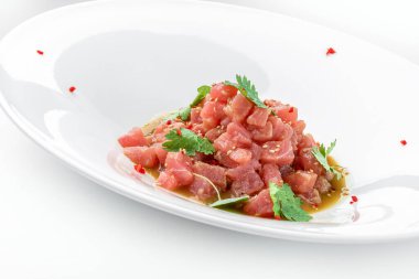 Ton balıklı tart, avokado ve sosla süslenmiş kişniş tabakta beyaz arka planda. Balık ve deniz ürünleri, yakın çekim, üst manzara.