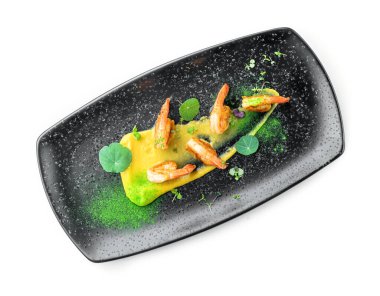 Soslu kızarmış karides, beyaz arka planda izole edilmiş mikroyeşilliklerle süslenmiş. Balık ve deniz ürünleri, yakın çekim, üst manzara.