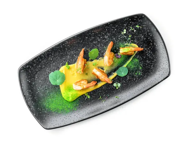 Soslu kızarmış karides, beyaz arka planda izole edilmiş mikroyeşilliklerle süslenmiş. Balık ve deniz ürünleri, yakın çekim, üst manzara.