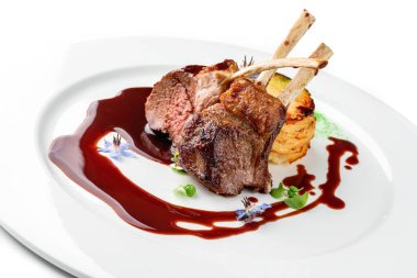 Kızarmış kuzu pirzolası ya da pirzola eti, sebze püresi ve beyaz arka planda izole edilmiş tabakta sos. Et tabakları, üst manzara, kapatın.