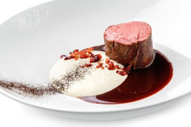 Izgara fileminyon biftek ya da ızgara et madalyonu. Beyaz arka planda izole edilmiş bir tabakta sos. Et tabakları, üst manzara, kapatın.