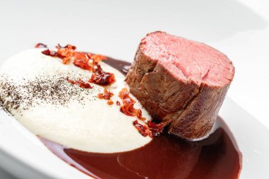 Izgara fileminyon biftek ya da ızgara et madalyonu. Beyaz arka planda izole edilmiş bir tabakta sos. Et tabakları, üst manzara, kapatın.