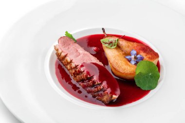 Izgara biftek ya da ızgara biftek madalyonu. Beyaz arka planda izole edilmiş fırında armut ve sosla birlikte. Et tabakları, üst manzara, kapatın.