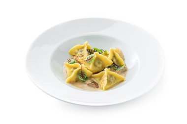 Soslu Ravioli, beyaz arka planda izole edilmiş yeşil tabakla süslenmiş. İtalyan yemekleri, üst manzara, kapat.