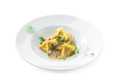 Soslu Ravioli, beyaz arka planda izole edilmiş yeşil tabakla süslenmiş. İtalyan yemekleri, üst manzara, kapat.