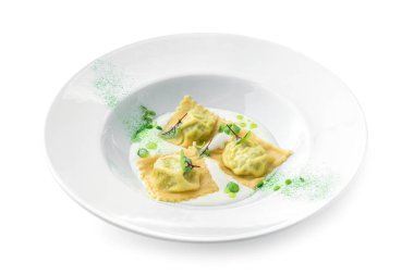 Beyaz arka planda, ıspanaklı Ravioli ve ekşi kremalı ricotta peyniri. Vejetaryen yemekleri, üst manzara, yakın çekim.