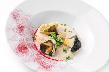 Beyaz arka planda izole edilmiş yeşilliklerle süslenmiş lezzetli ravioli. İtalyan yemekleri, üst manzara, kapat.