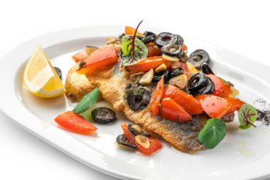 Izgara sebzeli, limonlu ve zeytinli fırında fileto balığı. Beyaz arka planda izole edilmiş. Deniz ürünleri, üst manzara, yakın çekim.