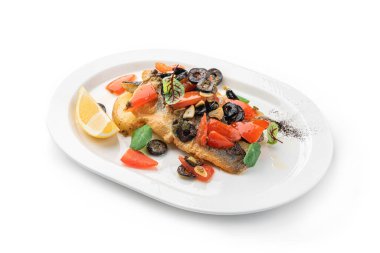 Izgara sebzeli, limonlu ve zeytinli fırında fileto balığı. Beyaz arka planda izole edilmiş. Deniz ürünleri, üst manzara, yakın çekim.