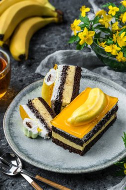 Muzlu kremalı çikolatalı bisküvi ve gri arka planda bir fincan çay, meyve ve çiçekli meyve jölesi. Tatlılar, tatlı ve pasta, üst manzara