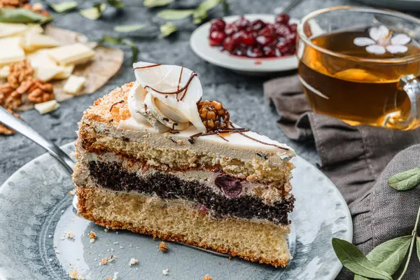 Bir parça kiraz ve kremalı bisküvi gri arka planda çiçekli. Tatlılar, tatlı ve pasta, ev yapımı kekler, yakın plan, seçici odaklanma
