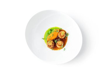 Balık havyarlı kızarmış deniz tarağı ve beyaz arka planda izole edilmiş tabakta sos. Deniz ürünleri, yakın çekim, üst manzara.