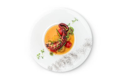 Beyaz arka planda izole edilmiş sebze ve soslu ızgara ahtapot. Sağlıklı yemek, üst manzara, yakın çekim.