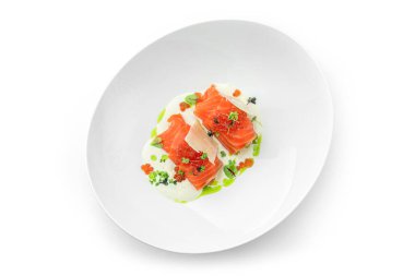 Somon ruloları ve soslu kırmızı havyar ve beyaz arka planda izole edilmiş yeşil tabaklar. Balık ve deniz ürünleri, yakın çekim, üst manzara.