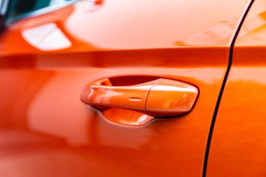 Turuncu, modern bir arabanın kapı kolunun yakın plan detayları.