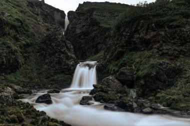 Karanlık kayalık dağlarda yüksek çağlayan şelale. Uzun pozlama fotoğrafı