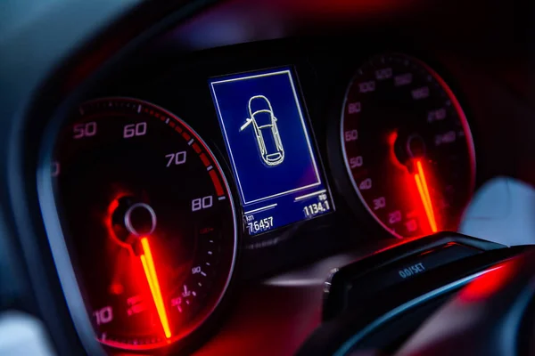 Arabanın yakın görüntüsü, turuncu iğneli yuvarlak araba tezgahları ve ön sürücünün kapılarının açık olduğunu gösteren bilgisayarı gösteriyor.. 