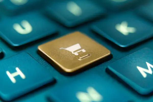 Ortasında beyaz araba simgesi olan altın rengi e-ticaret tuşu olan mavi klavyeye yaklaş