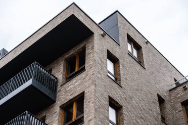 Üstü asılı çatı ve metal balkonu olan kentsel apartmanın köşesi, minimal mimari