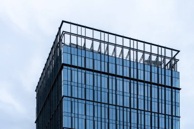 Camdan cepheli ve çatısı olan modern ofis gökdeleniName