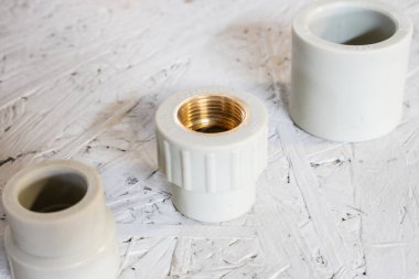 Ahşap yüzeyde plastik ve pirinç boru bağlantıları