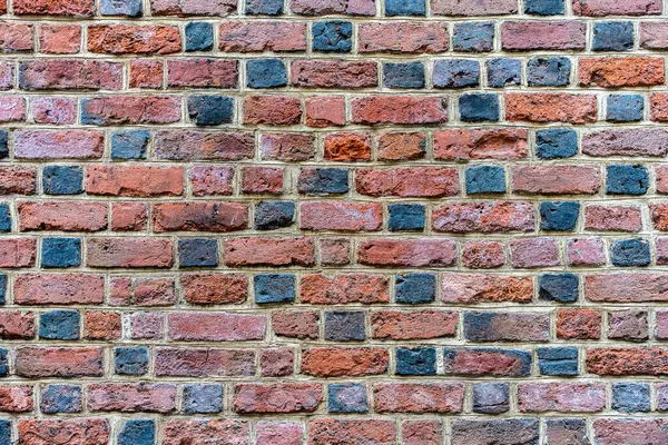 Değişik kırmızı ve siyah tuğlalı klasik tuğla dokusu, pürüzlü yüzey, inşaat malzemesi.