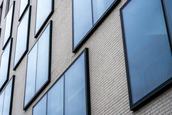 Bej tuğla bina cephesinden çıkan cam pencereler, modern mimari geometri