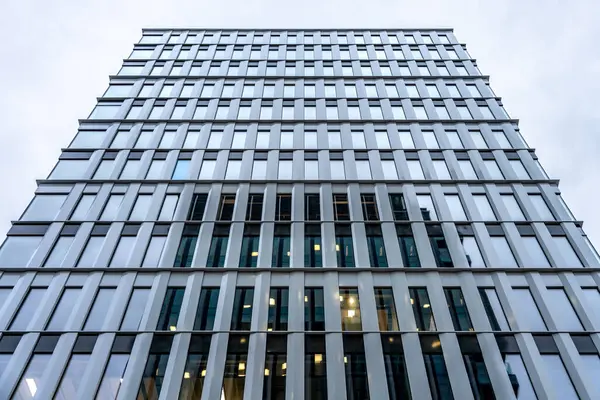 Tekrarlanan pencere desenli modern bir ofis binasının simetrik görüntüsü