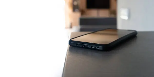 Akıllı telefon, modern, aydınlık bir iç mekanda masanın üzerinde duruyordu.