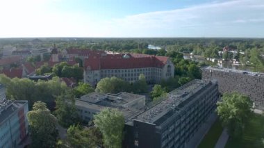 Wroclaw Bilim ve Teknoloji Üniversitesi üzerinde İHA uçuşu. Kırmızı çatılı tarihi bina ve modern kampüs mimarisi