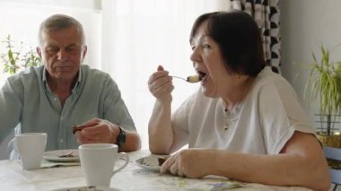 Tatlıyı ve kahveyi birlikte yiyen yaşlı bir çift. Açık sözlü yemek ve sohbet anı.