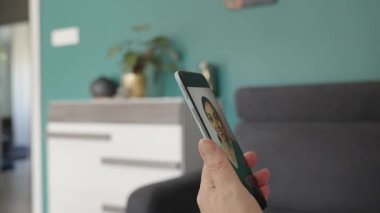 Üst düzey bir çift modern ev içinde akıllı telefon kullanarak rahat ve düşünceli ifadeler kullanıyor.