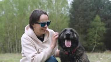 Ormanda mutlu Alman çoban köpeğini okşayan, neşeli ifadeler, evcil hayvan bakımı ve duygusal bağ teması