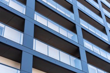 Polonya 'da mavi cepheli ve cam balkonlu modern konut binası, geometrik şehir mimarisi