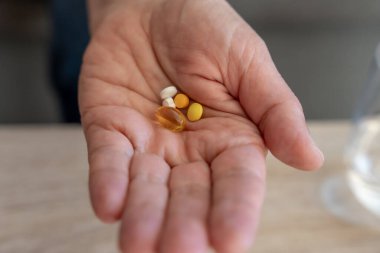 Renkli haplar ve takviyeler, sağlık ve tıp konseptinden oluşan el ele tutuşmalar.