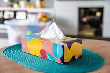 İçerideki ahşap masada beyaz kağıt mendilli renkli mendil kutusu. Polonya 'da canlı tasarım unsuru.