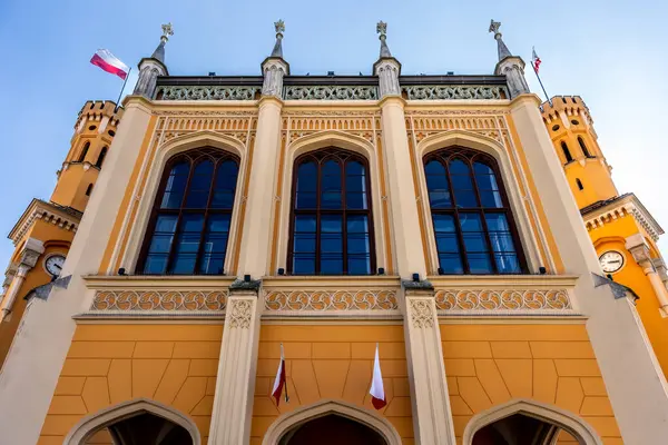 Wroclaw Tren İstasyonu Polonya bayrakları ve süslü kemerli pencereli turuncu cephe inşa ediyor.