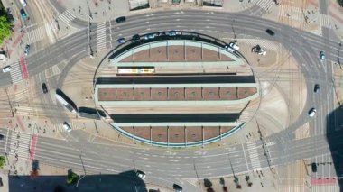 Trafik ve yayalarla dolu büyük şehir kavşağındaki modern tramvay istasyonunun havadan görünüşü. toplu taşıma kavşağı merkezi