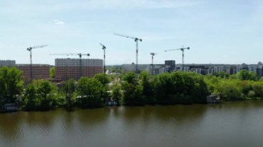 İHA 'dan alınan görüntülere göre, nehir kıyısında çeşitli vinçleri ve yeni apartmanları olan kentsel inşaat alanı. şehir gelişimi