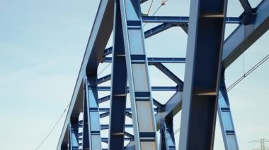 Mavi gökyüzünde tekrarlanan kirişlerle modern çelik köprü yapısı, mimari altyapı