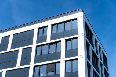 Polonya 'daki mavi gökyüzüne karşı modern minimalist siyah beyaz binanın düşük açılı görüntüsü şebeke benzeri pencere deseni ve çağdaş tasarımı ile